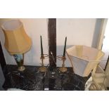 A pair of brass candlesticks and a modern metal li