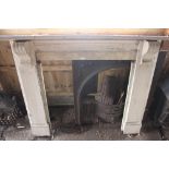 A painted pine fire surround with ornate cast iron