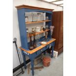 A kitchen dresser with plate rack and tile top