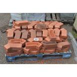 A pallet of red corner bricks