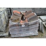 A pallet of used shaped roofing tiles