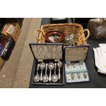 A basket of various cutlery and serviette rings; a