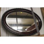 A mahogany oval and bevel edged mirror