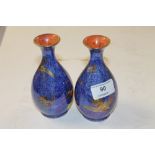 A pair of Wedgwood blue luster vases decorated wit