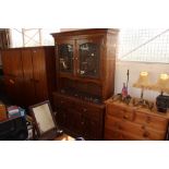 An oak bookcase raised on cupboard base, fitted tw