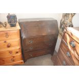 An oak bureau fitted three drawers