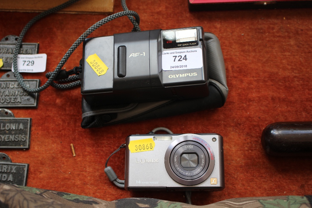 A Pansonic Lumix digital camera; and an Olympus au