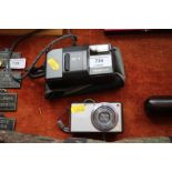 A Pansonic Lumix digital camera; and an Olympus au
