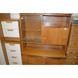 A teak bookcase raised on cupboard base fitted two