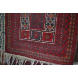 An approx. 4'10" x 2'10" red Eastern patterned rug