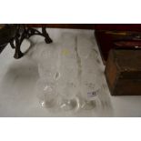 A set of twelve etched glass drinking glasses; and