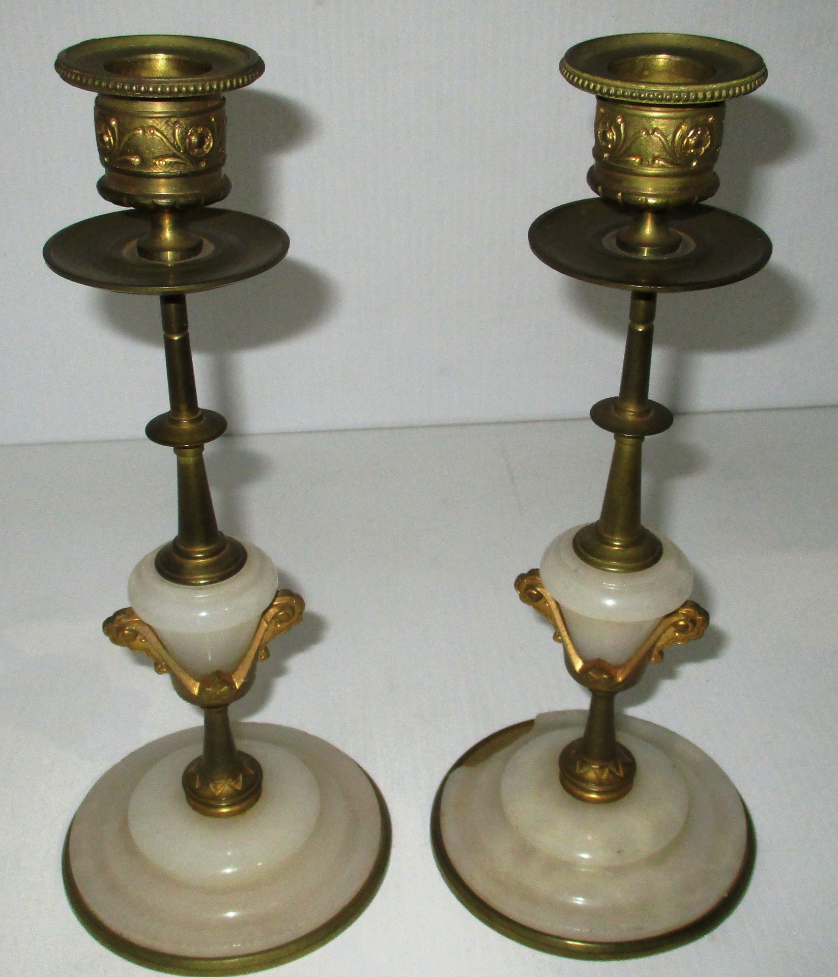 A small pair of brass and onyx candlesticks - 1 base damaged,