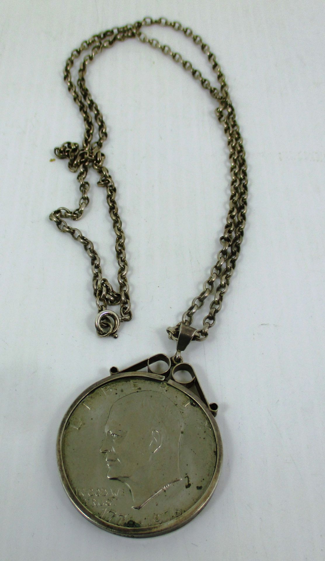 One Dollar coin in a silver mount on a silver chain