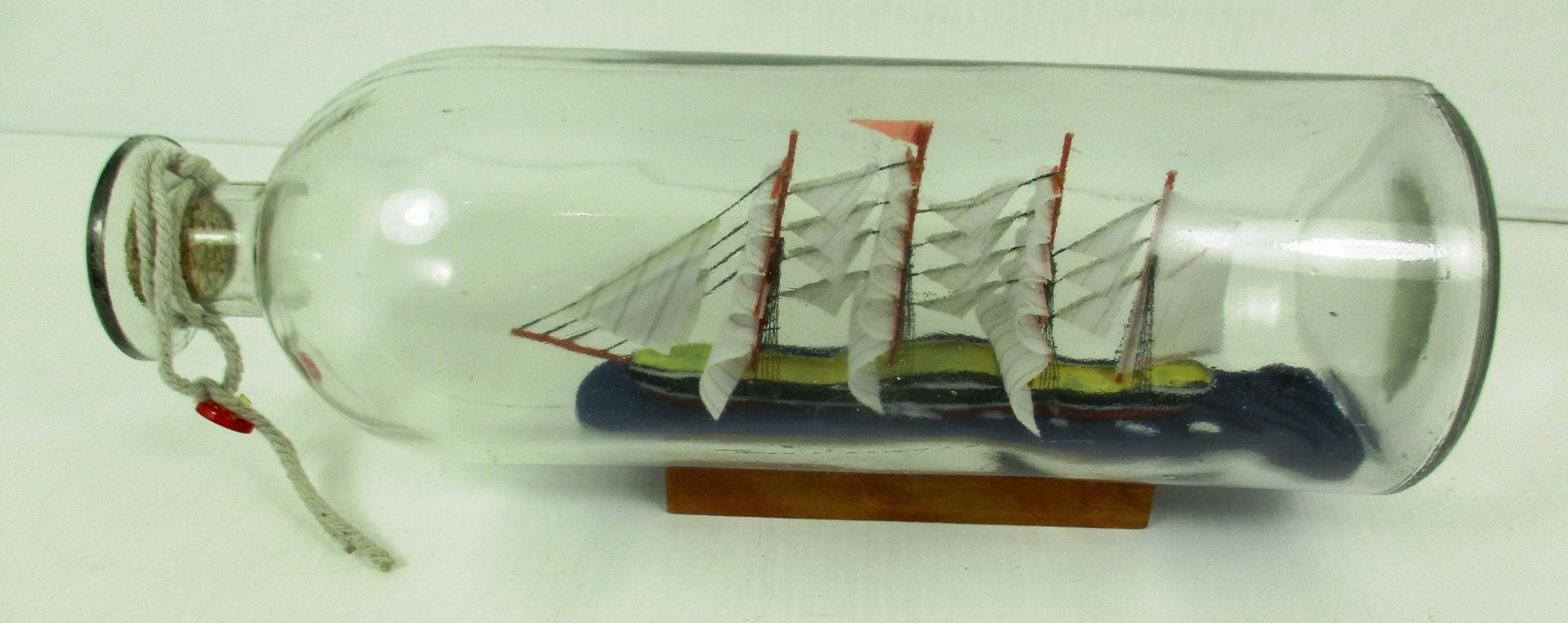 A Ship in a bottle on wooden plinth