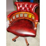 A reproduction mahogany framed office swivel armchair with oxblood deep buttoned back leather