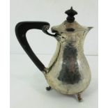 A silver teapot with ebonised loop handle and finial, on three bracket feet,