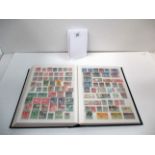 A stamp album containing World Stamps - GB overseas territories,