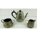 A three piece silver tea set, the teapot with ebonised scroll handle, embossed floral design,