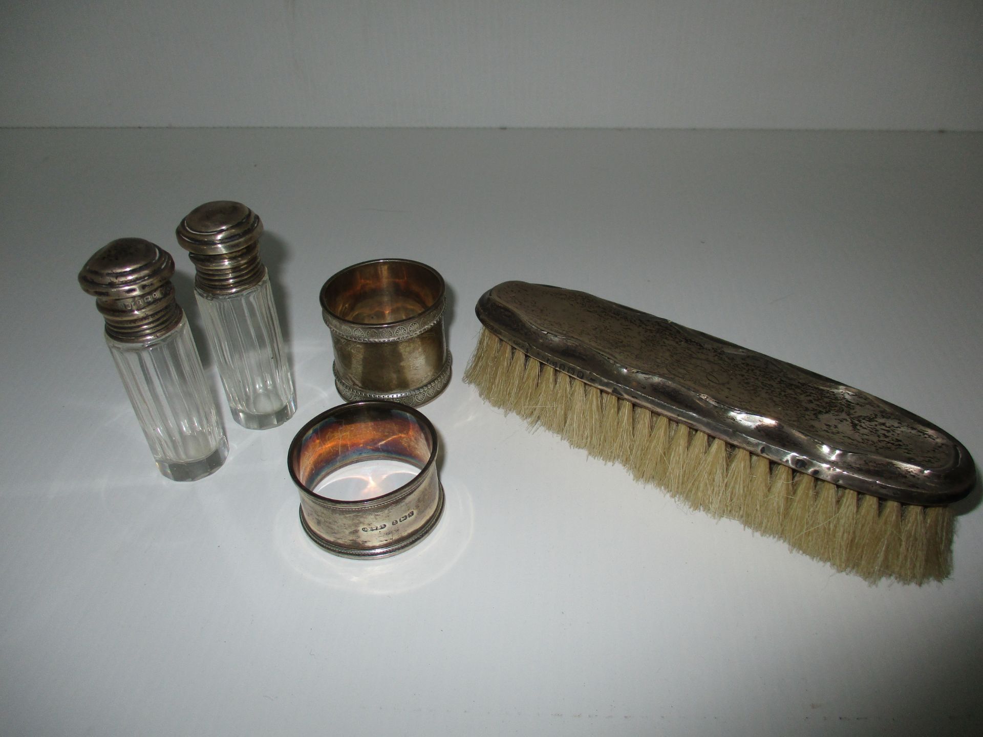 A silver napkin ring, two silver topped scent bottles,