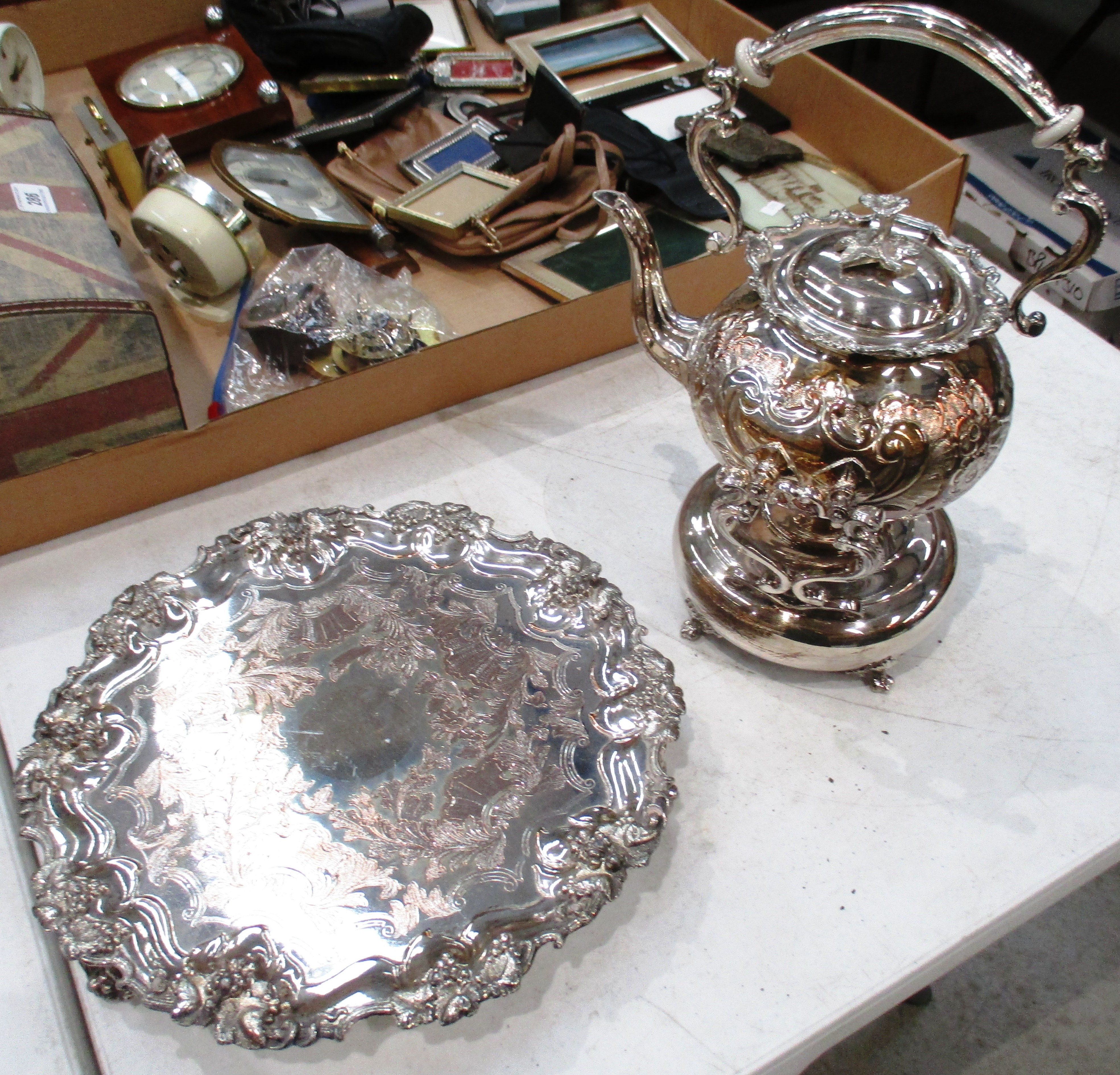 A circular silver plated tray with fruit and vine decoration,