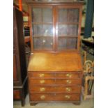 An oak bureau bookcase with two glazed doors over fall front four drawer base 104cm x 200cm high