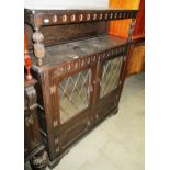 An oak side cabinet with 2 leaded glazed doors over 2 small doors 110cm