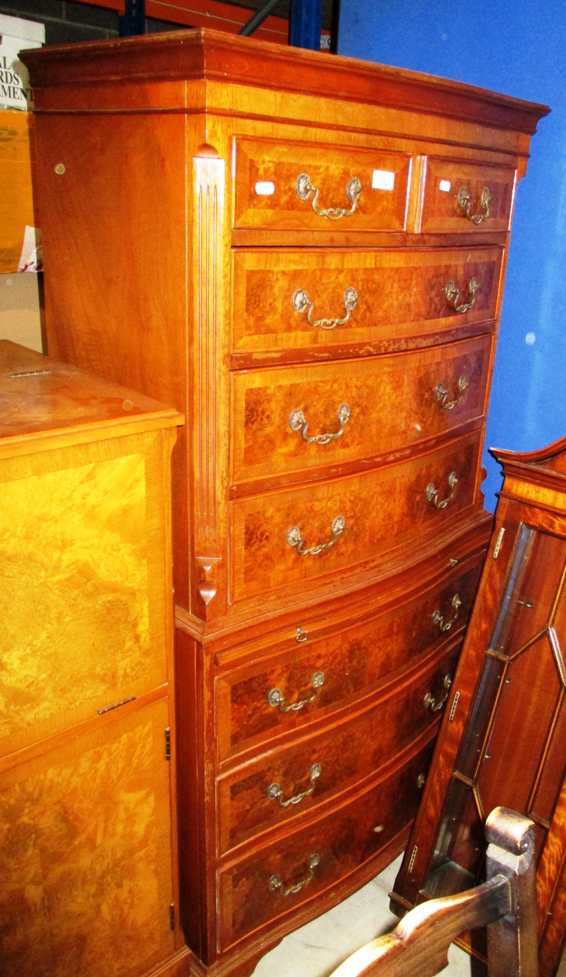 A reproduction serpentine front walnut 8 drawer chest of drawers (2 short,