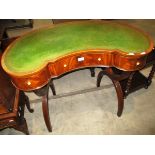 An inlaid mahogany kidney shaped writing desk with 3 frieze drawers and a green leatherette tooled