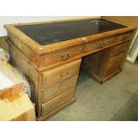 A stripped oak drawer kneehole desk with black leatherette incised top 153 x 62cm