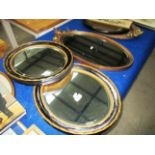 A pair of black and gilt framed oval mirrors and an ornate gilt framed mirror (3)