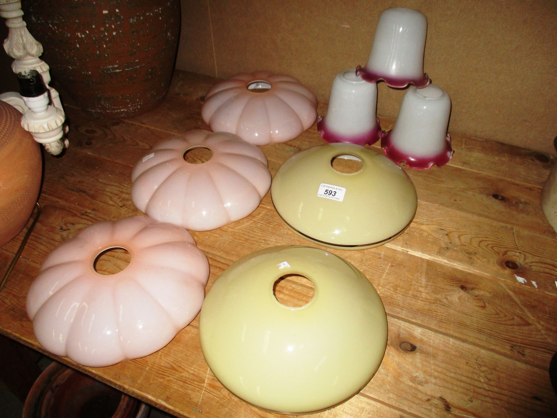 A set of 3 rose coloured glass light shades,