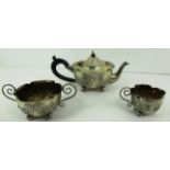 A three piece silver tea set, the teapot with flared rim, ebonised scroll handle,