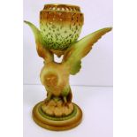 A Royal Worcester pierced vase supported upon a bird of prey base and circular foot,