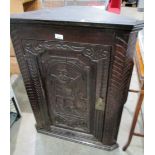 An oak corner cabinet with carved door 74 x 96cm high