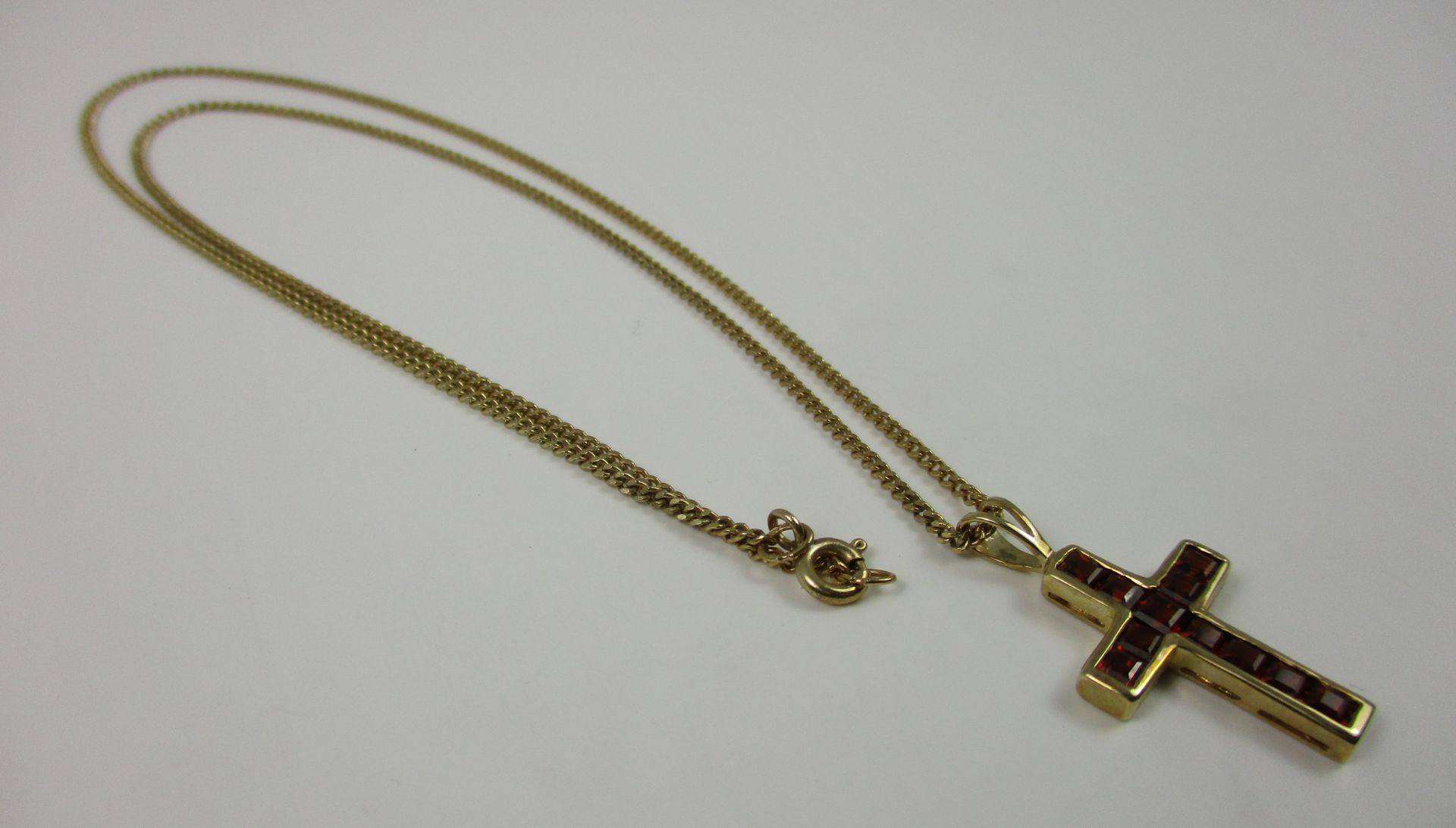 A 9ct gold chain with 9ct gold crucifix pendant set with red/orange stones [total approximate - Image 2 of 2