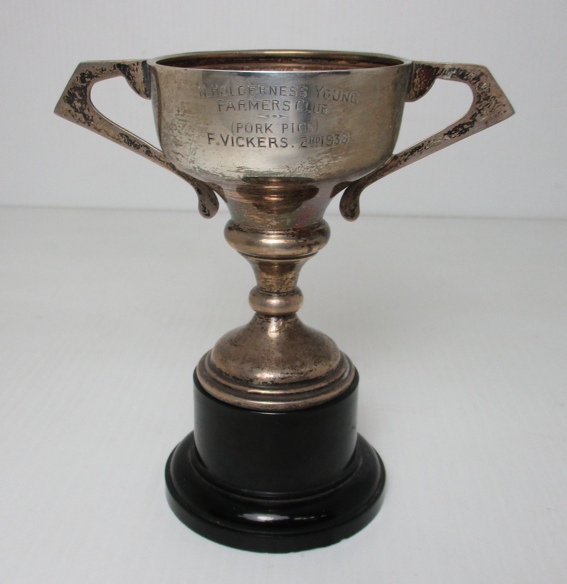 A silver trophy cup on plastic plinth,