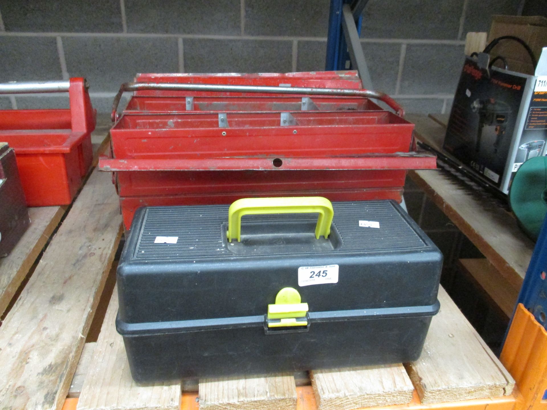 A red metal tool box with contents and a black plastic tool box with contents