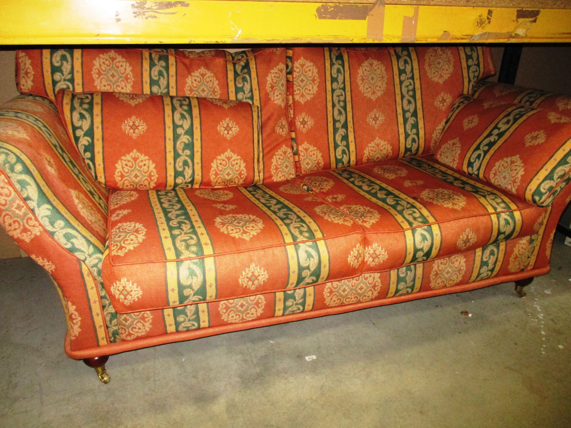 An orange and green patterned 3 seater sofa