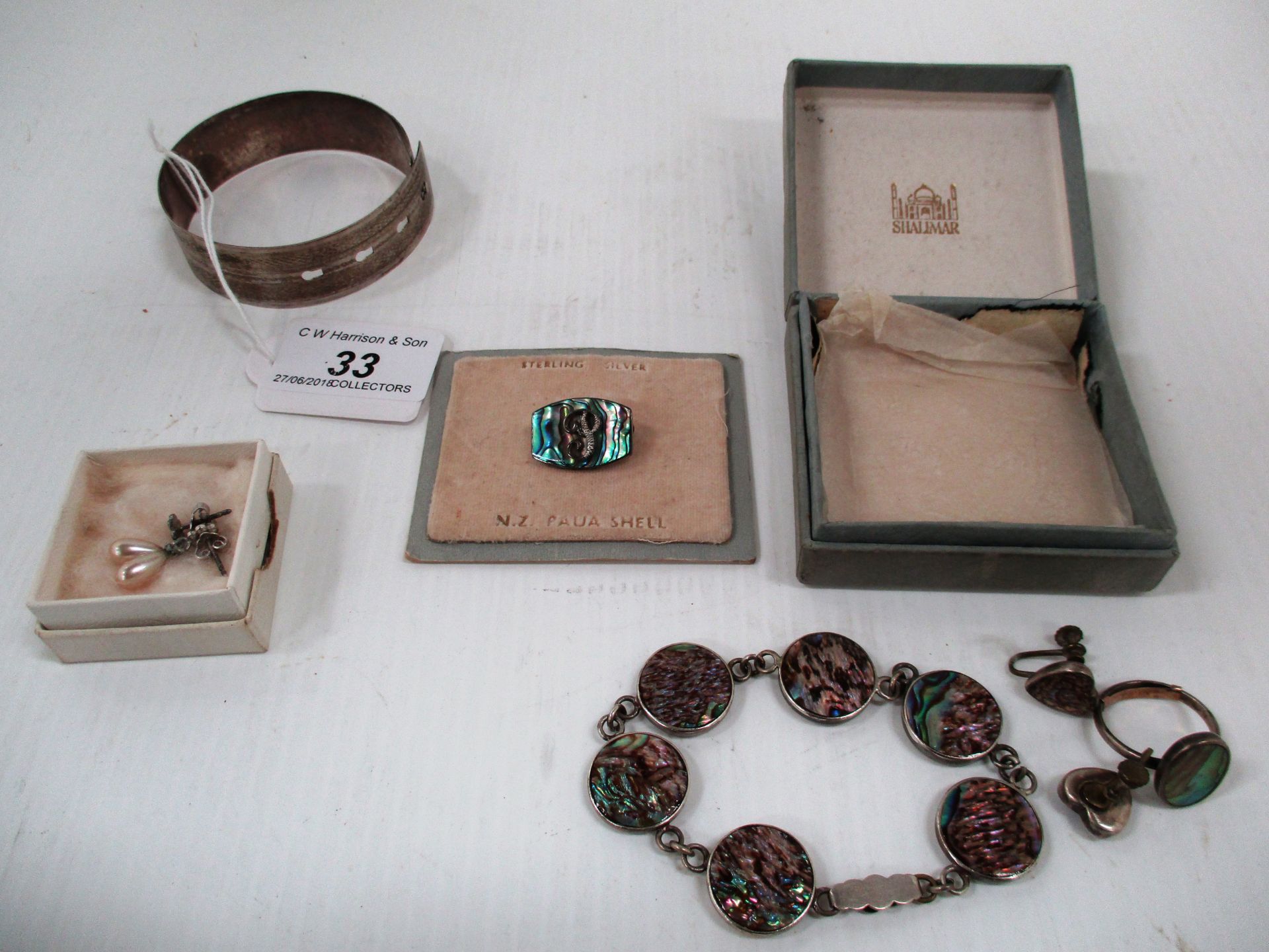 A silver bangle, brooch, pearl-like earrings and bracelet,