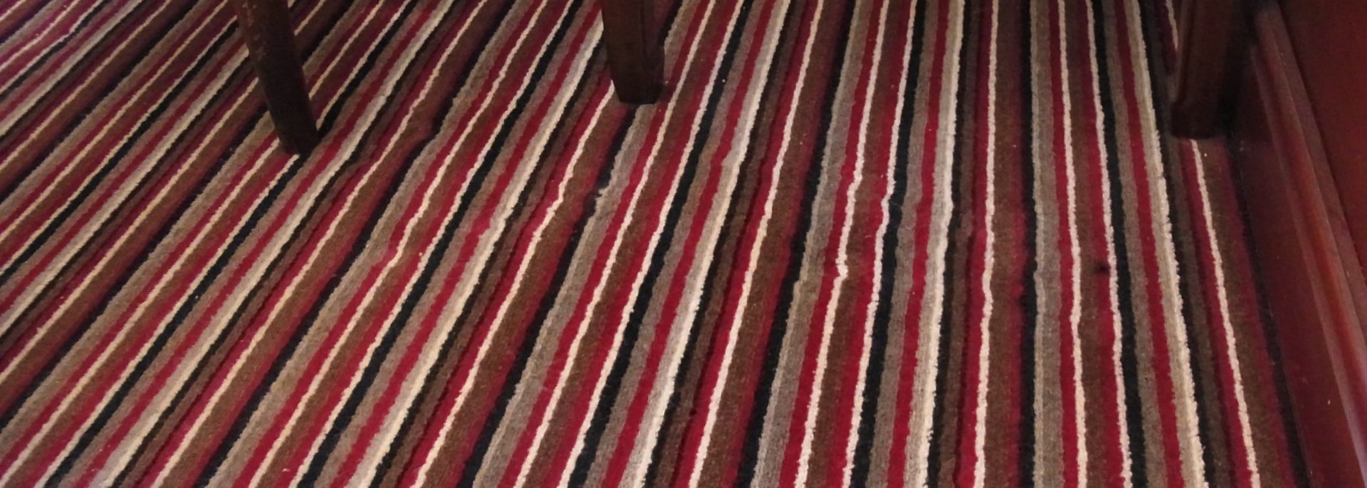 Multi striped carpet as installed to restaurant [approximately two years old]