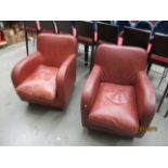 A pair of Habitat brown leather chairs on light wood feet