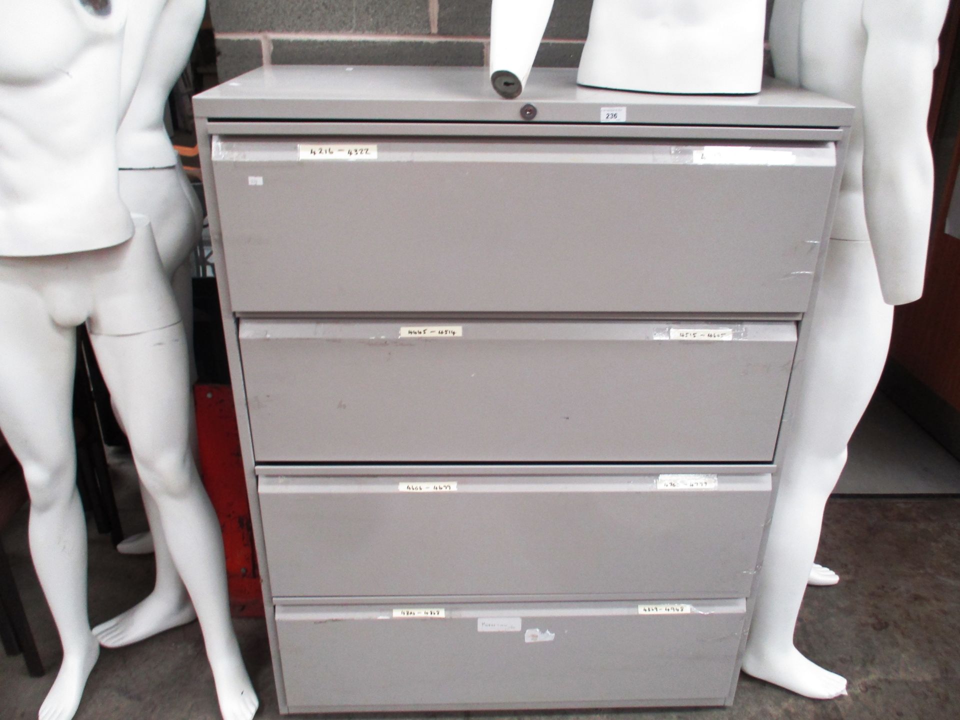 A grey metal four drawer lateral cabinet (unlocked no key)