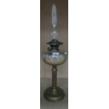 A brass oil lamp with a bulbous glass chimney