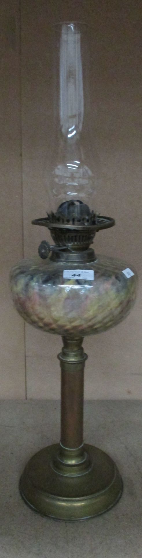 A brass oil lamp with a bulbous glass chimney