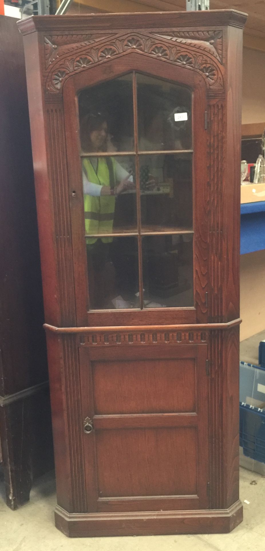 An oak corner cabinet with upper glazed door,