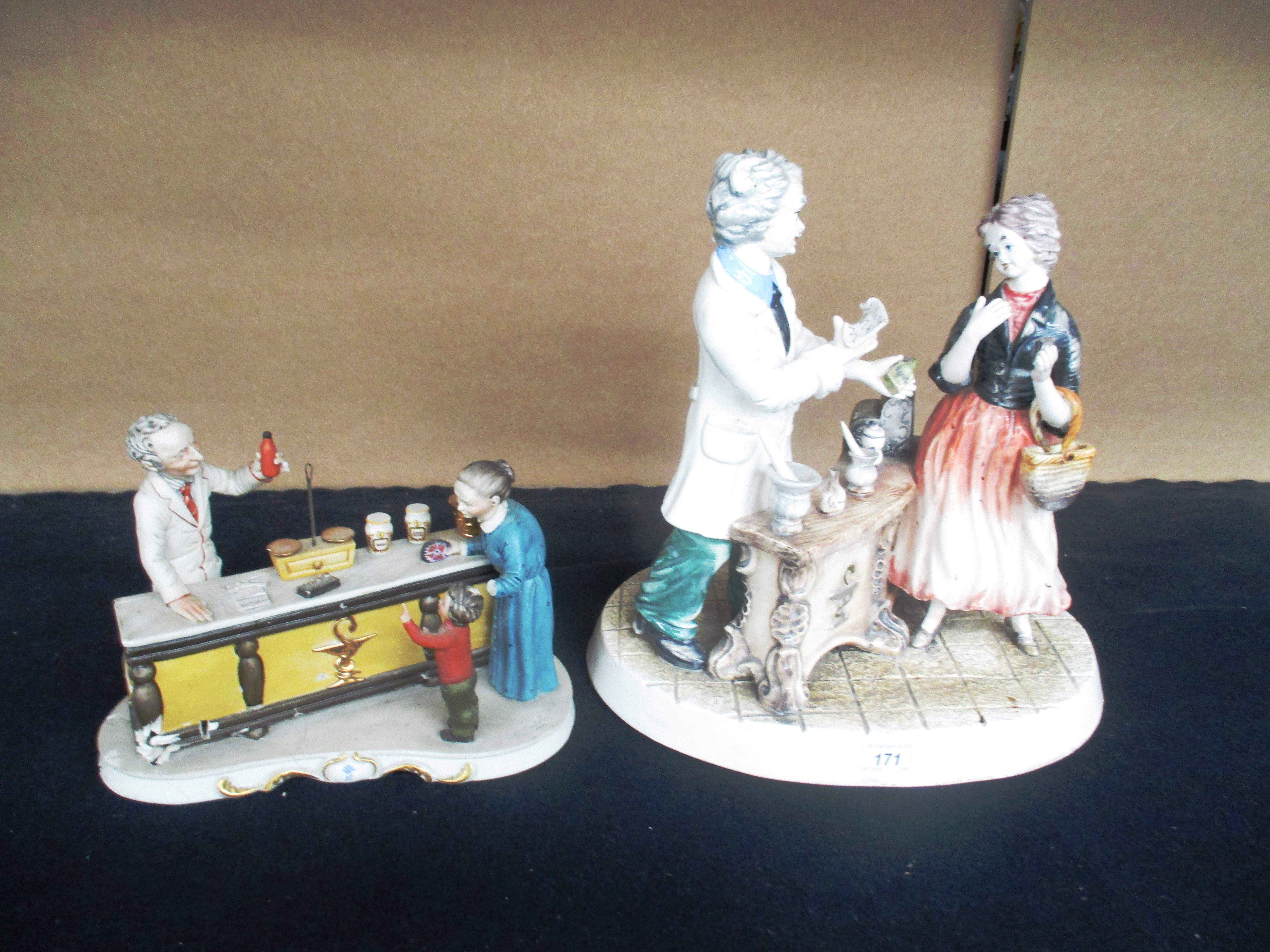 Two Capodimonte chemists shop figure groups, 37cm and 22cm high (the smaller at fault),