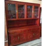 A Chinese medium wood display unit with four upper glazed doors over three drawer,