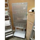 A clear plastic freestanding notice board on grey metal base