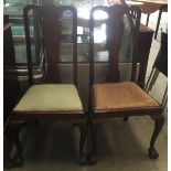 A pair of dining chairs with ball feet