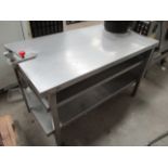 A stainless steel preparation table with under shelf and a manual can opener